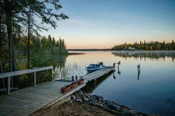 Båt på en lugn sjö vid solnedgången — Stockfoto