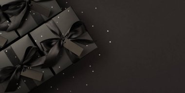 Siyah saten kurdele etiketli siyah hediye kutularının panoramik görünümü ve izole edilmiş siyah arkaplan ve boş alan ile pulları