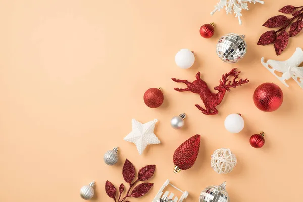 排成白色和红色圣诞装饰雪片迪斯科球明星圆锥鹿冰雪橇和小枝在孤立的米色背景与空旷的空间的顶部照片 — 图库照片