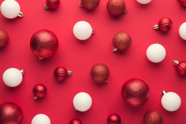 Kırmızı ve beyaz noel ağacı toplarının izole edilmiş kırmızı arkaplanda en üstteki görüntüsü