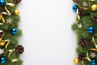 Altın ve mavi noel ağacı toplarının en üst görüntüsü kozalaklar küçük yıldızlar ve boş arkaplan ile izole beyaz arka planda çam dalları üzerindeki yılan balığı