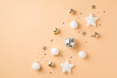 Sıra kompozisyonu beyaz ve altın noel ağacı süslemeleri Disko topları parlak yıldızlar ve izole edilmiş bej arkaplan üzerindeki pullar boş alan