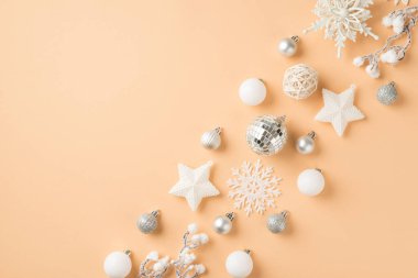 Sıra kompozisyonu beyaz ve gümüş Noel ağacı süslemeleri Disko topları yıldızlar ve izole edilmiş bej arka planda kar taneleri