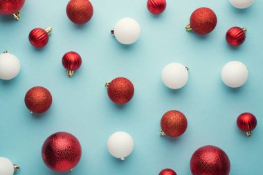 İzole edilmiş pastel arka planda beyaz ve kırmızı noel ağacı kürelerinin en üstteki görüntüsü