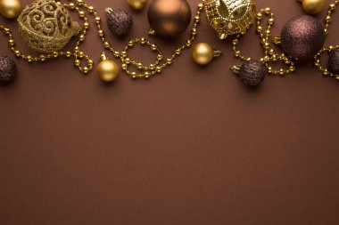 Parlak altın ve kahverengi noel ağacı topları ve izole edilmiş kahverengi arka planda altın sakallı çelenk fotoğrafı.