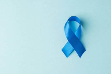 Üst görünüm mavi saten kurdele sembolü prostat kanseri bilinci izole edilmiş pastel mavi arkaplan üzerinde boş alan