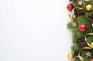 Noel ağacı süslemelerinin en üst görüntüsü altın ve kırmızı toplar çam kozalakları parlak yıldızlar ve izole edilmiş beyaz arka plandaki çam dalları üzerinde yılan balığı