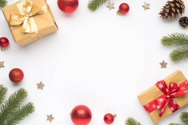 Çam dallarının en üstteki fotoğrafı kırmızı noel ağacı topları koni yıldızları ve izole edilmiş beyaz arka planda fiyonklu hediye kutuları ortada kopyalanmış boşluklar