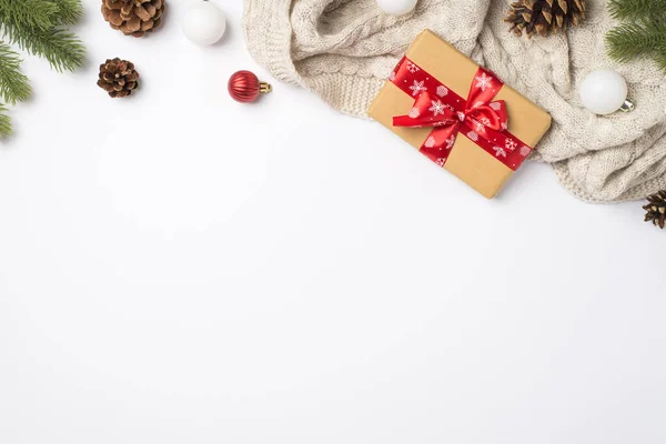 松の枝のトップビュー写真は コピースペースと隔離された白い背景に赤いリボン弓居心地の良いニットセーター赤と白のクリスマスツリーボールとクラフト紙のギフトボックスをコーン — ストック写真
