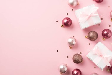 Pembe noel dekorasyonunun en üstteki fotoğrafı konfeti ve pembe kurdeleli beyaz hediye kutuları kopyalanmış pastel pembe arka planda