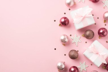 Pembe noel dekorasyonunun en iyi fotoğrafı kar taneleri konfetileri ve pembe kurdeleli beyaz hediye kutuları kopyalanmış pastel pembe arka planda