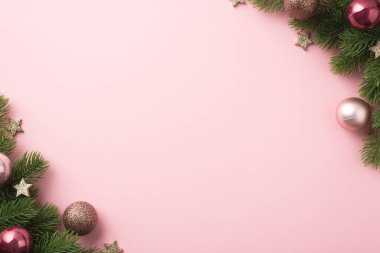 Noel süslerinin en üst görüntüsü. Pembe topları olan çam dalları ve izole edilmiş pastel pembe arka planda parlayan yıldızlar.