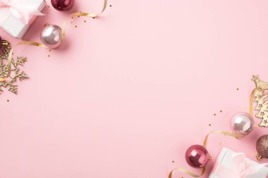 Noel süslerinin en üst görüntüsü pembe toplar altın çam tanesi şekilli süsler beyaz hediye kutuları altın yılanlar ve izole edilmiş pastel pembe arka planda boş alan pulları.