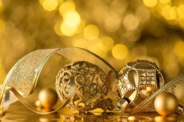 Altın Noel ağacının yakın plan fotoğrafı süslemeler toplar yılanbalığı ve parlak altın bokeh arka planda kurdele