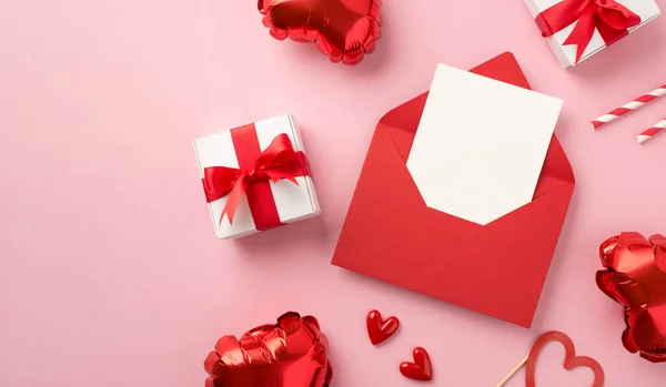 Top view photo of st valentine's day decorations open red envelope with paper sheet small hearts gift boxes straws and heart shaped balloons on isolated pastel pink background with empty space