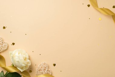 Beyaz gül sarısı ipek kurdele, kalp şekilli konfeti ve rattan kalplerin izole edilmiş bej arkaplan, boş alan.