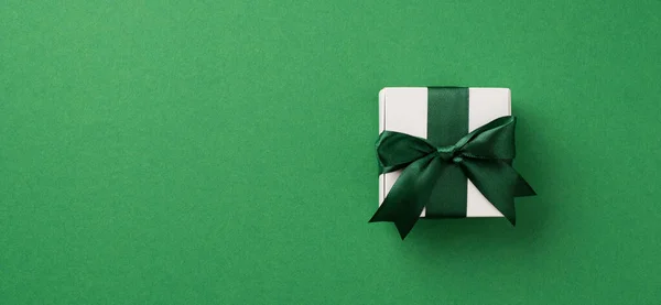 圣诞装饰品白色礼品盒顶景照片 绿色彩带蝴蝶结 独立绿色背景 有彩色空间 — 图库照片