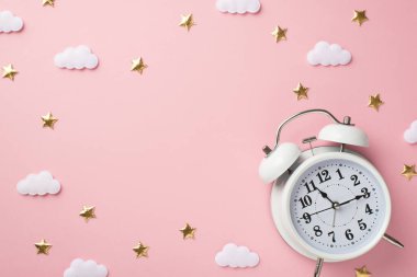 Top view photo of white alarm clock golden stars and clouds on isolated pastel pink background with blank space