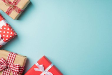 Sevgililer Günü dekorasyonunun en üst görüntüsü kırmızı ve el işi kağıt hediye kutuları ile izole edilmiş pastel mavi arka plan ve kopyalanmış
