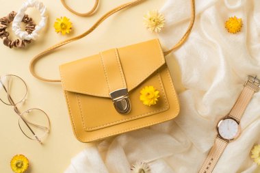 Kadınlar günü kompozisyonu sarı deri çanta stil gözlük toka altın kol saati ve izole edilmiş bej arka planda tarla çiçekleri