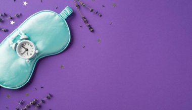 Saten mavi göz maskesi ve üzerine beyaz alarm konfetisi serpiştirilmiş yıldızlar şeklinde mor lavantalı menekşe izole boş arka plan