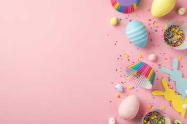 Paskalya süslemelerinin en üst görüntüsü Paskalya tavşanı siluetleri çok renkli paskalya yumurtaları kağıt kalıpları izole edilmiş pastel pembe arka plan üzerindeki şekerleme kalıpları