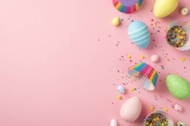 Paskalya süslemelerinin en üst görüntüsü çok renkli paskalya yumurtaları kağıt kalıpları ve kaplama kalıpları izole edilmiş pastel pembe arka plan üzerinde şekerleme malzemesi