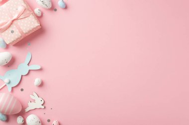 Paskalya dekorasyonunun en üst görüntüsü hediye kutusu konfeti konfetileri paskalya tavşanları izole edilmiş pastel pembe arka planda mavi ve beyaz paskalya yumurtaları boş alan