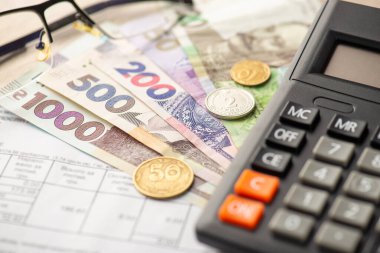 Hesap makinesi faturalarının fotoğrafı Ukrayna Hryvnia banknotları ve sikkeleri gösteriyor