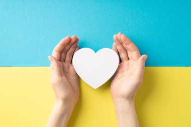 Ukrayna 'daki savaşı durdurun. Kızın el fotoğrafı ulusal bayrak üzerinde beyaz kalbi gösteriyor.