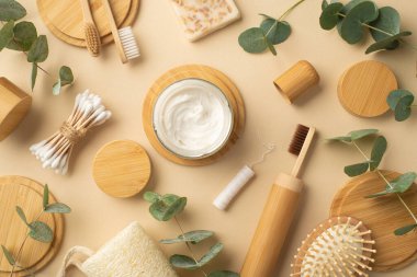 Plastik konsept yok. Diş macunuyla kavanozun üst görüntüsü doğal kozmetik sabun diş fırçası saç fırçası pamuk tomurcukları yeşil bitki yaprakları ve ahşap ayaklar izole edilmiş bej arka plan