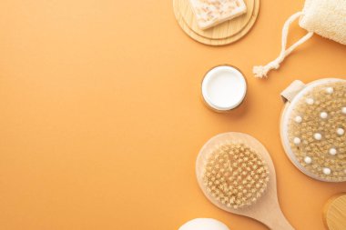 Plastik konsept yok. Spa aksesuarlarının, ahşap tezgahta selülit önleyici sabunun ve kopyalanmış bej arka planda losyonlu şişenin en üst görüntüsü.