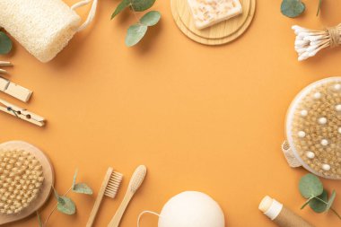 Spa aksesuarları anti-selülitli banyo bezi sabunları ahşap ayakta duruyor pamuk tomurcuklar diş fırçaları çamaşır mandalları ve izole edilmiş bej arka planda okaliptüsler ortada kopyalanmış bej alanlar