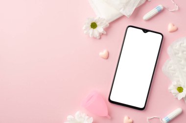 Akıllı telefon pembe kalplerin üst görüntüsü papatya tomurcukları adet bardağı hijyenik pedleri ve izole edilmiş pastel pembe arka plan üzerinde boş alan.