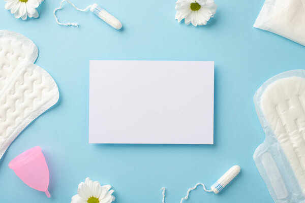 Вид сверху фото бумажного листа ромашки почки гигиенические салфетки розовые менструальные чашки и тампоны на изолированном пастельно-голубом фоне с пустым местом