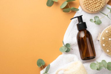 Doğal kozmetik konsepti. Cam dağıtıcı şişesinin üst görüntüsü anti-selülit havlu ve izole edilmiş bej arka planda okaliptüs boş alan