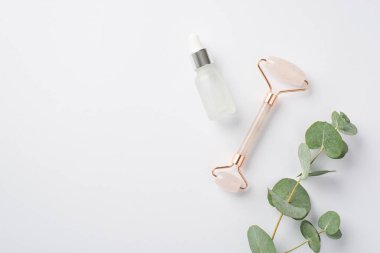 Okaliptüs gül kuvars rulo ve cam şişe üst görünüm fotoğraf izole beyaz zemin