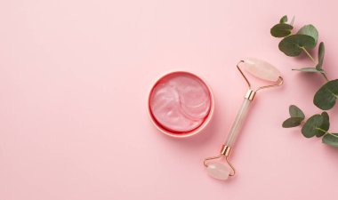 Okaliptüs gül kuvars rulo ve pembe göz bantları üst görünüm fotoğraf izole pastel pembe arka plan ile kopyalanmış