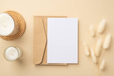 El işi kağıdının en üst görüntüsü kağıt kağıtlı mumlar rattan plasemat üzerinde ve beyaz lagurus çiçekleri izole edilmiş bej arka planda kopyalanmış