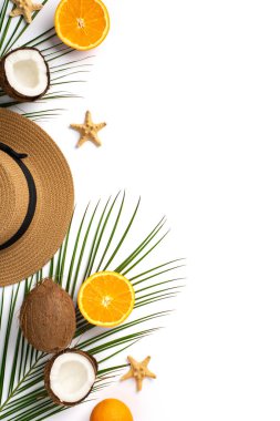 Yaz tatili konsepti. Güneş şapkalı, tropikal meyvelerin dikey fotoğrafı. Hindistan cevizi, turuncu deniz balıkları ve izole edilmiş beyaz arka planda yeşil palmiye yaprakları. Boş alan.