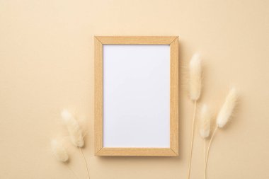 İş konsepti. Ahşap fotoğraf çerçevesi ve beyaz lagurus çiçeklerinin izole edilmiş bej arkaplandaki boş arkaplan görüntüsü
