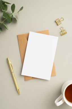 İş konsepti. Kağıt kaplama kağıt zarf dikey fotoğraf altın cilt ataç çay fincanı ve okaliptüs pastel gri arkaplan