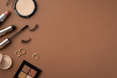 Makyaj güzellik konsepti. Göz fotografının en üstteki resmi sahte kirpikler, rimel altın halkalar ve izole edilmiş kahverengi arkaplan üzerinde ruj.