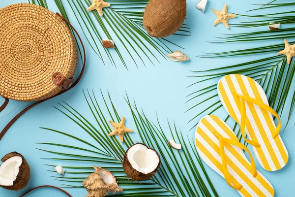Yaz haftasonu konsepti. Yuvarlak rakun çantasının üst görüntüsü sarı çizgili terlikler Hindistan cevizi deniz yıldızı kabukları ve izole edilmiş pastel arka planda palmiye yaprakları.