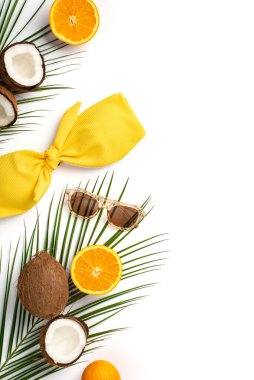 Yaz tatili konsepti. Sarı mayo gözlüklerinin dikey resmi. Hindistan cevizi, portakal ve palmiye yaprakları.