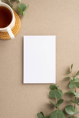 Kağıt yaprak okaliptüs yaprakları dikey fotoğraf ve bej arkaplan üzerinde rattan servis paspası üzerinde çay boş alan