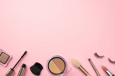 Makyaj konsepti. Palet ruj, sahte kirpikler makyaj fırçaları, rimel ve göz farı, pastel pembe arka planda fotokopi aletiyle.