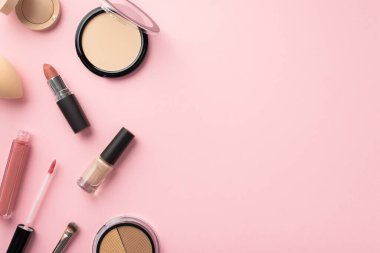 Güzellik konsepti uydur. Renkli palet pudralı ruj makyajının en üst görüntüsü güzellik blender dudak parlatıcısı parlatıcısı ve fotokopi alanlı pastel pembe arka planda göz boyası.