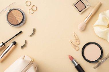 Makyaj fırçası, makyaj fırçası, rimel, saç tokaları, pastel bej arka planda makyaj malzemesi ve makyaj malzemesi.