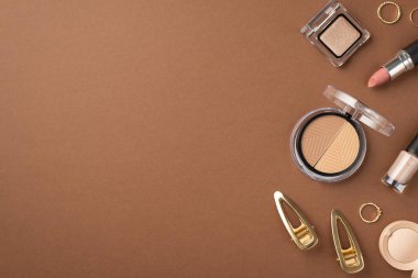 Makyaj güzellik konsepti. Göz fotografı. Göz farı. Palet altın halkalar. İki saç tokası ve izole edilmiş kahverengi arka planda ruj.